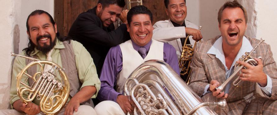M5 Mexican Brass band members laughing and holding brass musical instruments