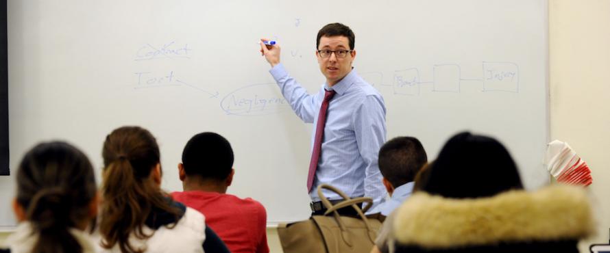Assistant Professor of Business Law Richard Kilpatrick standing in front of a whiteboard in a classroom of students