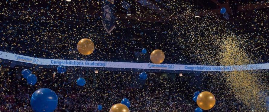 Blue and gold balloons and confetti fall from the rafters of the UIC Pavilion
