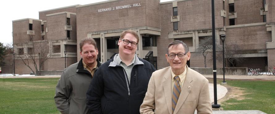 Bernard J. Brommel (right) poses in front of Bernard J. Brommel Hall with his sons Bradley (left) and Blair.