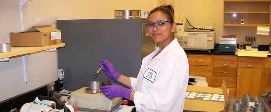 Cindy Calderon studying rock samples in a lab.