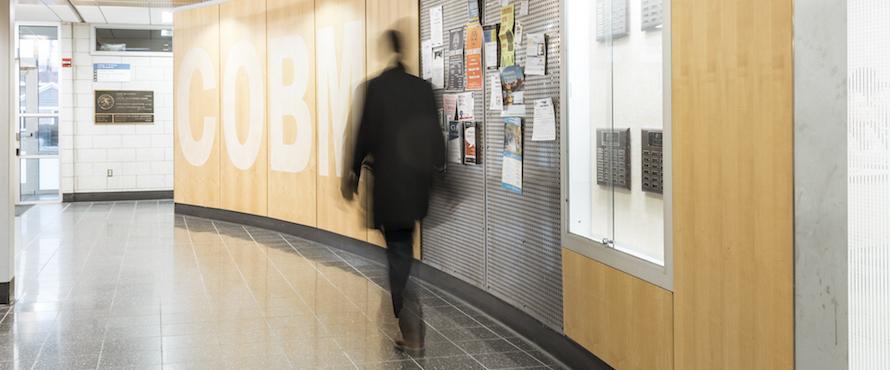 A person walks in the hallways of the College of Business and Management