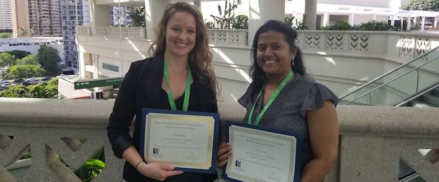 Annie Fritz and Latha Saradha hold their awards