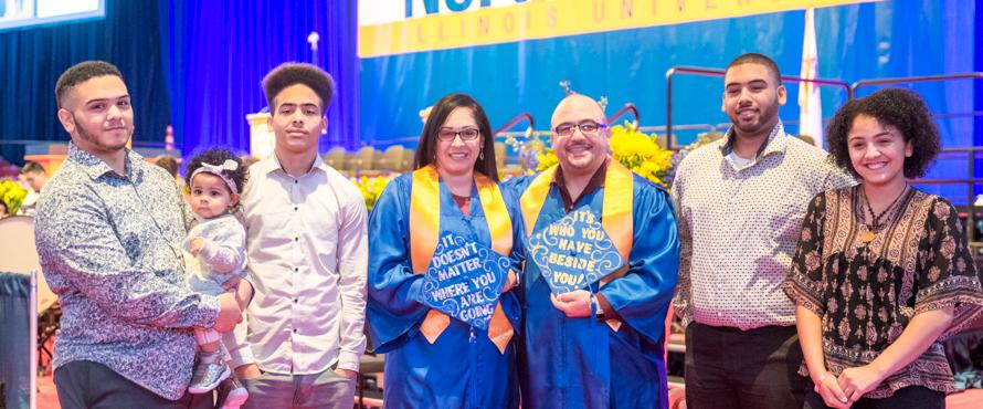 Photo of Ruby and Joel Rodriguez (center) surrounded by their children and grandchild at NEIU's December 2019 Commencement