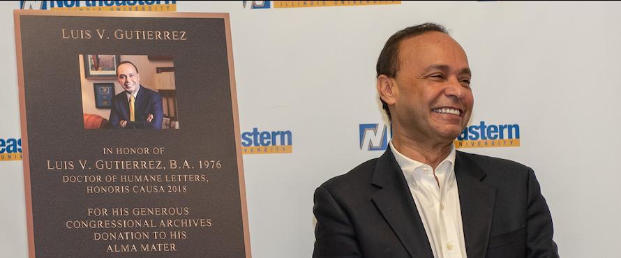 Luis Gutierrez stands smiling in front of a plaque bearing his name