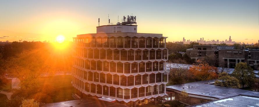 The sun rises behind the Sachs Building
