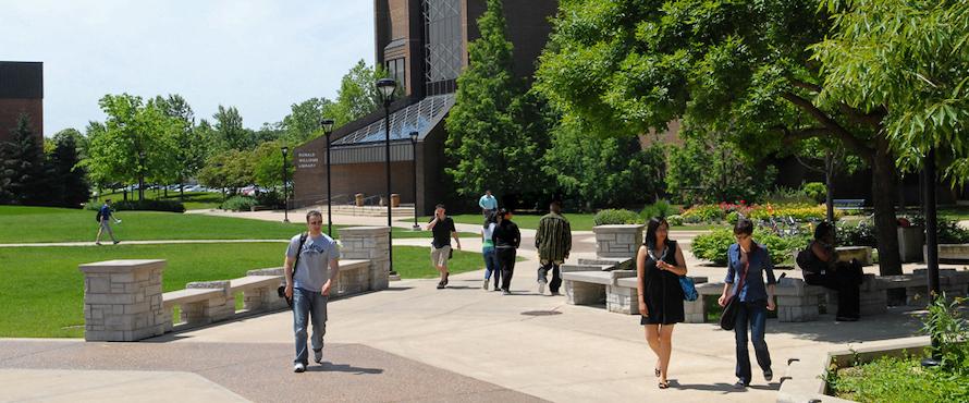 A photo of people walking around Northeastern's University Commons on a sunny day.
