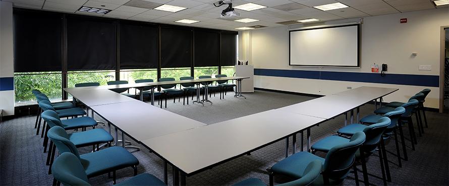 An empty conference room with a table and chairs.