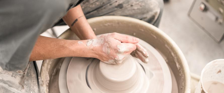 Close up of ceramics student working on pottery wheel