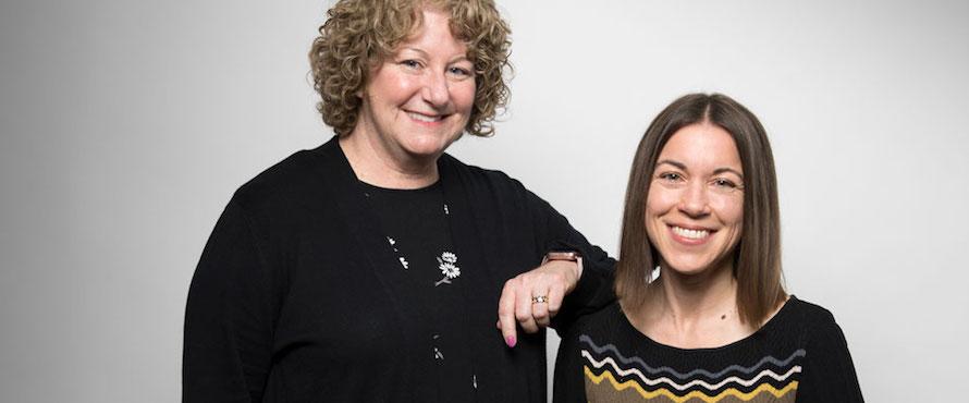 Photo of Sarah Gershon (left) in a black shirt and Jennifer Banas (right) in a black, yellow, and gray zig-zag top against a gray background