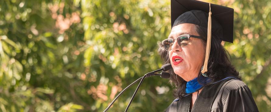 Ana Castillo recites a poem while wearing regalia.