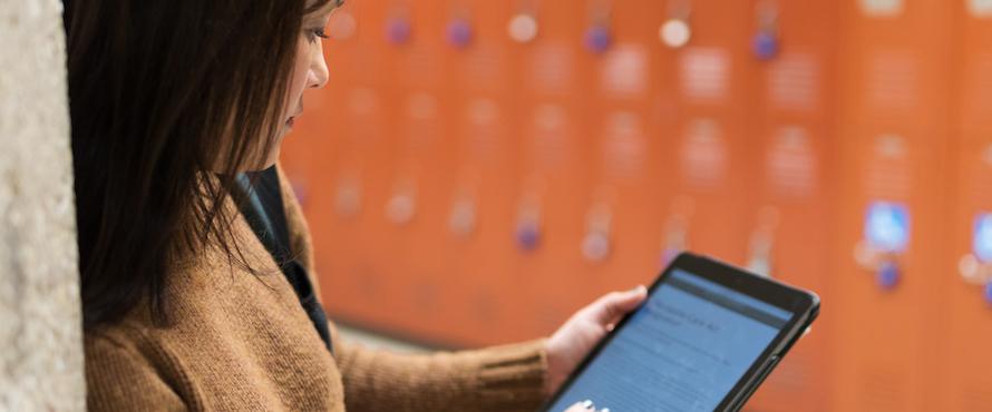 A woman holds a tablet device.
