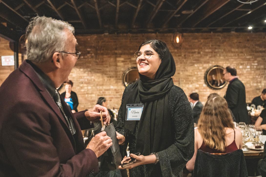 A student passing a gift bag to another person