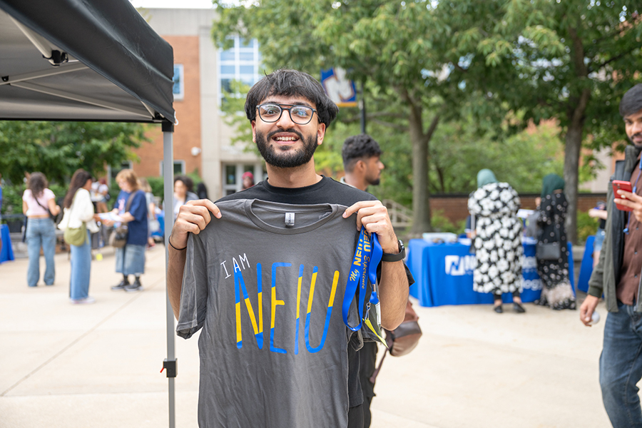 Male student posing with "I am NEIU" t-shirt.