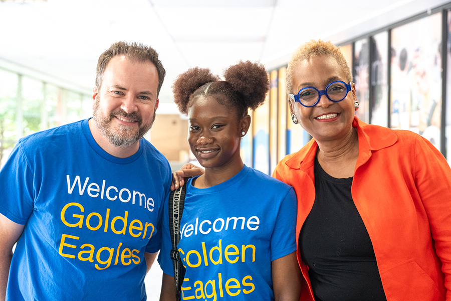 Two teachers posing with a student.