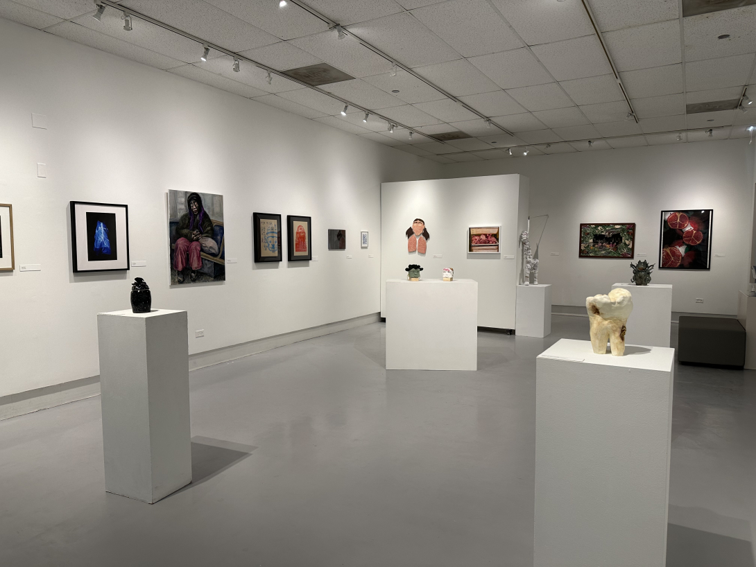 view of a gallery space with various mediums of visual artwork on display