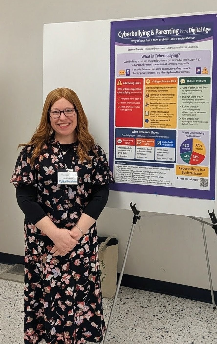 Student standing in front of research poster.