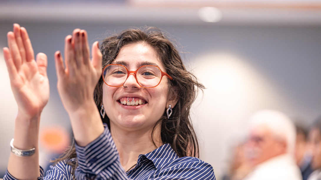 Woman applauding at event.