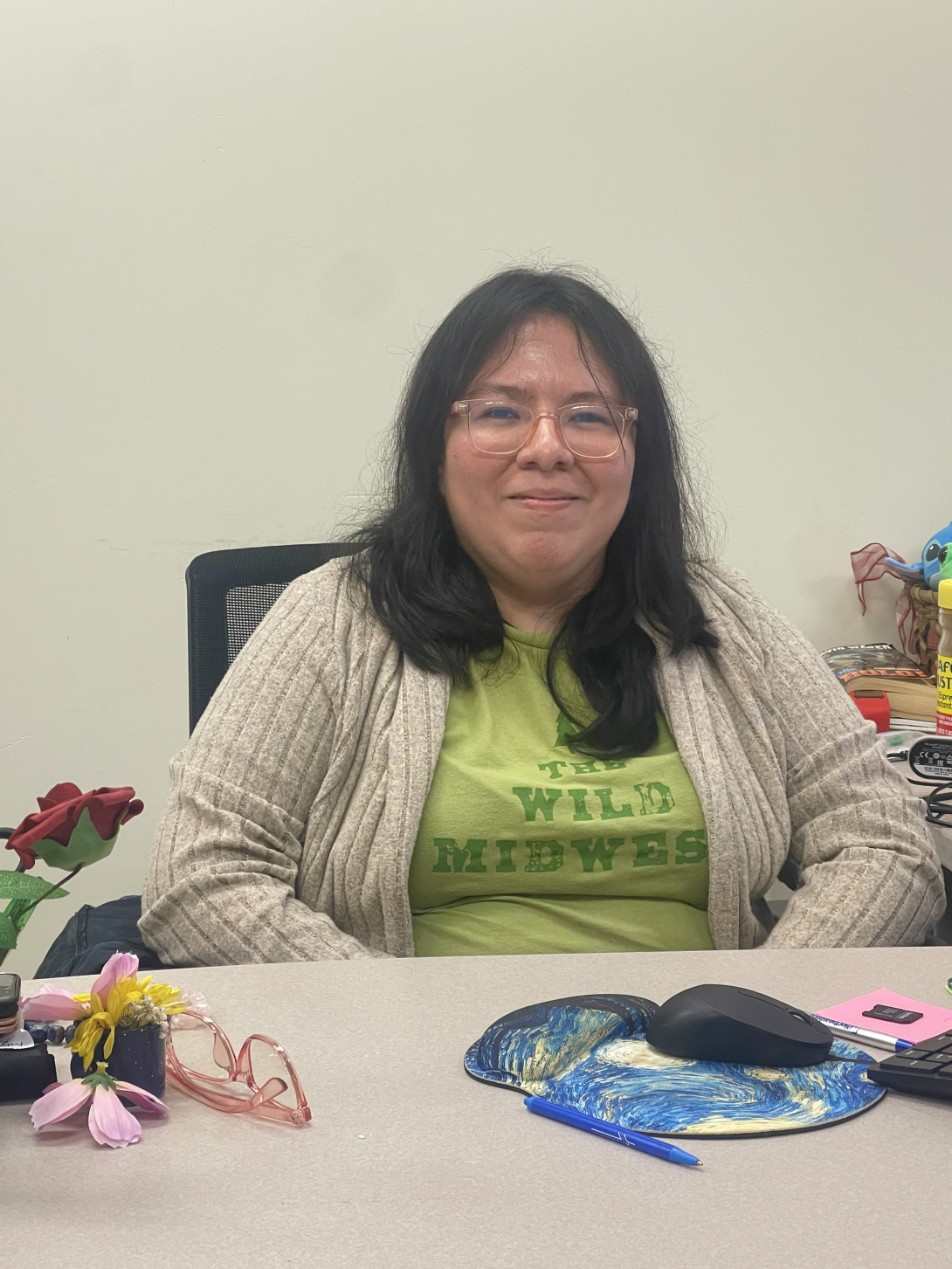 Leslie Lozada at her desk smiling with a white background