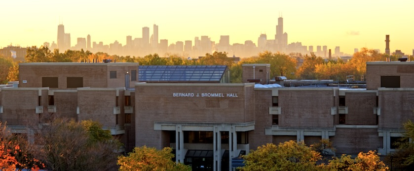 A photo of Northeastern Illinois University's Main Campus facing Bernard J. Brommel Hall with the Chicago Skyline in the background during sunrise. 