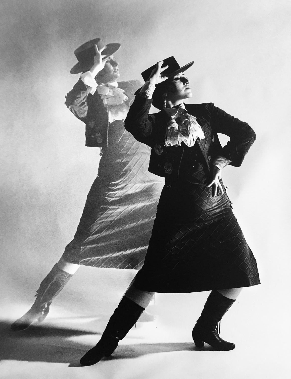 Crystal Ruiz, daughter of Ensemble Español's Artistic Director Irma Suárez Ruiz, in Dame Libby’s actual Flamenco Zapateado costume striking the same pose as Dame Libby, featured in the background. 