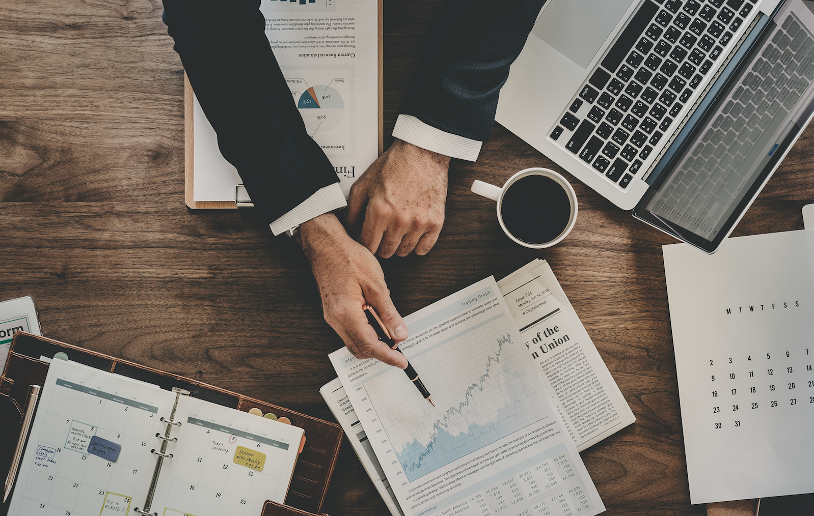 documents with data spread out on desk with man explaining them