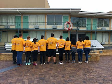 A group of Alternative Spring Break students in yellow shirts visit the site of Dr. Martin Luther King's assassination