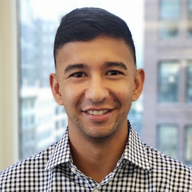 A man in a collared shirt smiles into the camera.