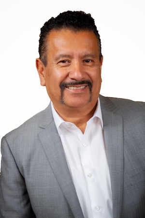 Photo of Richard P. Montañez wearing a white button-down shirt and gray suit jacket