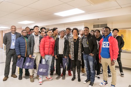 More than a dozen young men pose with President Gibson at the 6th Annual Young Men of Color Summit at Northeastern