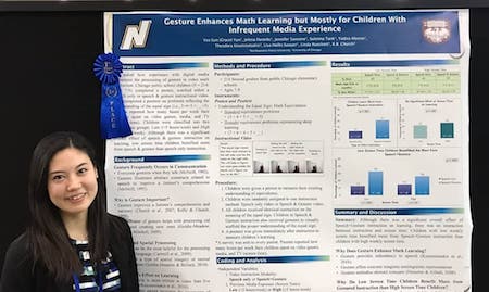 Grace Yun smiles while standing in front of her winning poster presentation.