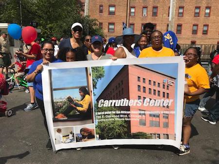 Parade participants hold a CCICS banner during the 4th on 53rd Independence Day Parade in Hyde Park on July 4, 2018.