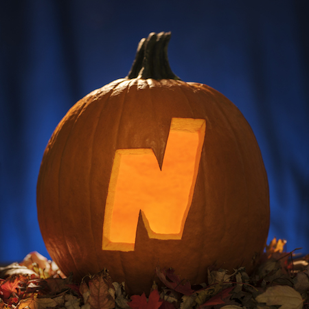 The Northeastern Illinois University "N" logo is carved into a pumpkin.