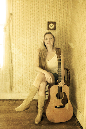 Rebecca Frazier seated holding a guitar