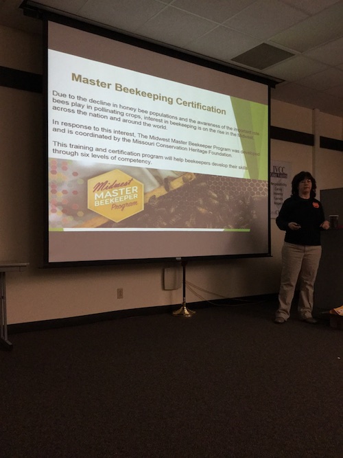 Moneen Jones stands in front of a projection screen while leading a beekeeper class