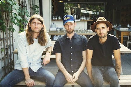 The three members of the West Pointers band pose on a bench.