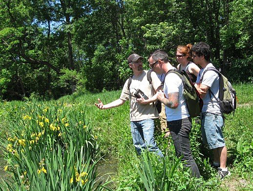 "Ken sharing with students in the green field"