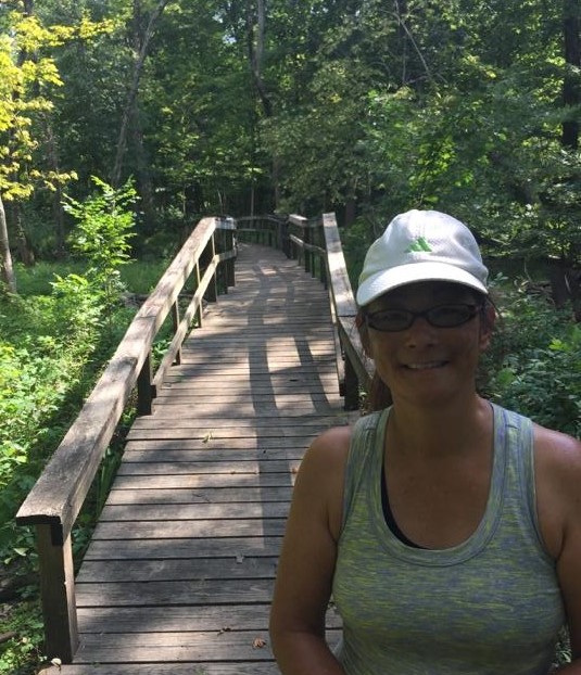 "Maureen in front of a wooden bridge"